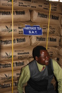 Blantyres Projektkoordinator Sylvester Mitini-Nkhoma vor fertig verpacktem Fairtrade-Tee